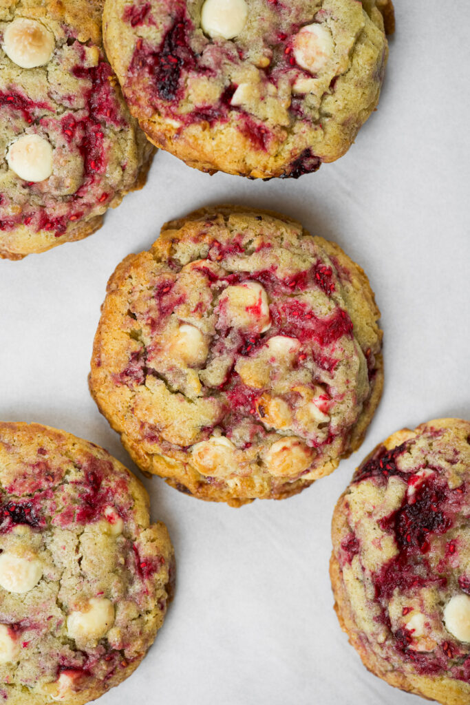 Cookie de framboesa com chocolate branco em cima de uma superfície