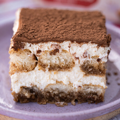 Close de tiramisu clássico mostrando as camadas de biscoito embebido no café e creme